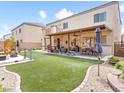 Spacious backyard with lush lawn, patio, playset, and shaded area for outdoor entertaining at 1604 Patrick Thomas Ct, North Las Vegas, NV 89086