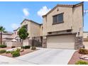 Stunning view of the home's exterior showcasing desert landscaping, covered entry, and two-car garage at 1604 Patrick Thomas Ct, North Las Vegas, NV 89086