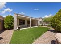 Relaxing backyard with a covered patio, manicured landscaping, and desert rock at 2029 Poppywood Ave, Henderson, NV 89012
