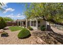 Landscaped backyard featuring synthetic grass, desert landscaping, and a covered patio at 2029 Poppywood Ave, Henderson, NV 89012