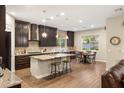A gourmet kitchen with dark wood cabinets, granite countertops, a large island, and stainless steel appliances at 2116 Canvas Edge Dr, Henderson, NV 89044
