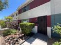 Inviting townhome exterior with decorative front door and manicured landscaping at 225 Greenbriar Townhouse Way, Las Vegas, NV 89121