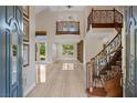 Grand foyer boasts soaring ceilings, tile flooring and a curved staircase at 3010 Hammerwood Dr, Las Vegas, NV 89135