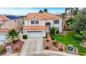 Two story stucco home with tile roof, lush lawn, mature trees and attached two car garage at 4 Tarryall Ter, Henderson, NV 89074