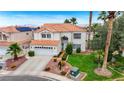 Two story stucco home with tile roof, lush lawn, mature trees and attached two car garage at 4 Tarryall Ter, Henderson, NV 89074