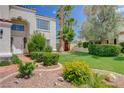 A well-maintained front yard with lush green lawn, mature trees, colorful flowers, and meticulous landscaping at 4 Tarryall Ter, Henderson, NV 89074