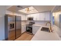 Modern kitchen featuring white cabinets, subway tile backsplash, stainless steel appliances, and quartz countertops at 5040 Spencer St # D, Las Vegas, NV 89119