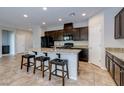 Gorgeous kitchen with granite countertops, dark wood cabinets, stainless appliances and a breakfast bar at 5412 Dalle Valley St, North Las Vegas, NV 89031