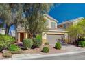 Front yard and facade of two-story residence with desert landscaping and covered entry at 5852 Brown Tree Ln, North Las Vegas, NV 89081