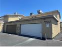 Exterior shot of garages at Little Pine Way, showing a white door and a brown door side by side at 6420 Little Pine Way, Las Vegas, NV 89108
