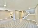 Spacious living room features light gray laminate flooring, fresh paint, and staircase to the second floor at 6420 Little Pine Way, Las Vegas, NV 89108