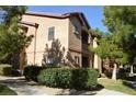 Tan condo complex with maintained bushes, sidewalks, and greenery at 8250 N Grand Canyon Dr # 2154, Las Vegas, NV 89166