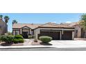 Inviting single-story home with a tile roof, desert landscaping, and a spacious driveway leading to a two-car garage at 8847 W Katie Ave, Las Vegas, NV 89147