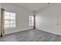 Bright bedroom features gray floors, white walls, and two windows with neutral drapes at 9330 W Maule Ave # 212, Las Vegas, NV 89148