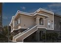 Exterior view of a two-story condo building with brown stucco, a concrete staircase, and well-maintained landscaping at 9330 W Maule Ave # 212, Las Vegas, NV 89148