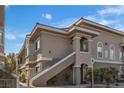 Exterior view of a tan two-story condo with stairs and well-maintained landscaping at 9330 W Maule Ave # 212, Las Vegas, NV 89148