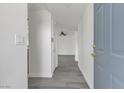 Hallway with neutral walls, gray wood floors, and a view into the living area, showcasing a clean and bright interior at 9330 W Maule Ave # 212, Las Vegas, NV 89148