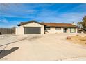Charming single-story home with a large driveway, attached garage, neutral color scheme, and well-maintained landscaping at 9340 W Washburn Rd, Las Vegas, NV 89149