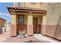 Inviting front entrance with a covered porch, decorative pillars, desert landscaping, and neutral colors at 952 Crescent Falls St, Henderson, NV 89011
