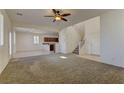 Open-concept living room with large windows, carpet flooring, staircase, and a view of the kitchen at 952 Crescent Falls St, Henderson, NV 89011