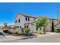A two-story townhouse with stucco exterior, tile roof, and a well-maintained front yard on a sunny day at 9931 Cherry Melee Ave, Las Vegas, NV 89148