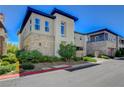 Modern two-story home with stone accents, manicured landscaping, and a contemporary design under a clear blue sky at 11280 Granite Ridge Dr # 1035, Las Vegas, NV 89135