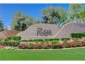 Community sign: The Ridges, surrounded by vibrant flowerbeds, green grass and mature landscaping under a blue sky at 11280 Granite Ridge Dr # 1035, Las Vegas, NV 89135