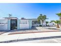 Inviting home featuring a decorative white fence, desert landscaping, and a neatly maintained front yard at 1521 Sombrero Dr, Las Vegas, NV 89169