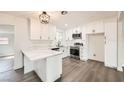 Bright kitchen showcases white cabinets, stone countertops, stainless steel appliances and a stylish light fixture at 1829 E Saint Louis Ave, Las Vegas, NV 89104