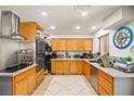 Well-lit kitchen with wooden cabinets, modern appliances, and sleek countertops at 251 Las Palmaritas Dr, Las Vegas, NV 89110