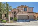 Two-story house with desert landscaping featuring a two car garage and a well maintained lawn at 280 Goldstar St, Henderson, NV 89012