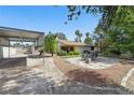 Spacious backyard features desert landscaping, a covered carport, and a cozy outdoor dining area at 4409 W Red Coach Ave, North Las Vegas, NV 89031