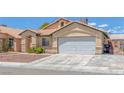 Inviting single-story home with desert landscaping, features a two-car garage and a well-maintained front yard at 4619 Reliant St, North Las Vegas, NV 89031