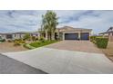 Attractive single-story home with a three-car garage, xeriscaping, and combination driveway at 6060 N Conquistador St, Las Vegas, NV 89149