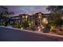 Elegant home exterior with stone accents, landscaped front yard, and illuminated pathway leading to the entrance at 628 Chervil Valley Dr, Las Vegas, NV 89138