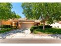 Charming single-story home with lush landscaping, mature trees, and a two-car garage at 8516 Millsboro Dr, Las Vegas, NV 89134