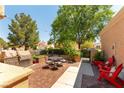 Inviting outdoor patio area featuring a built-in grill, seating, string lights and mature trees at 8516 Millsboro Dr, Las Vegas, NV 89134
