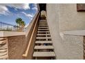 Exterior stairway leading to the upper-level units showing the stucco facade and iron railing at 9303 Gilcrease Ave # 2198, Las Vegas, NV 89149