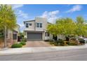 Contemporary two-story home featuring desert landscaping, a stone facade, and a two-car garage at 9710 Hiking Ave, Las Vegas, NV 89166