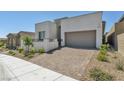 Contemporary home showcasing a well-manicured front yard with desert landscaping and neutral stucco at 11707 Hatchling Ave, Las Vegas, NV 89138