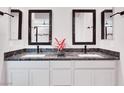 Bathroom featuring double sinks with granite countertops, modern fixtures, and framed mirrors at 2386 Millergrove Ave, North Las Vegas, NV 89086