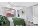 Light, bright bedroom featuring a queen size bed and view to the backyard at 2386 Millergrove Ave, North Las Vegas, NV 89086