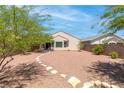 Private backyard featuring gravel landscaping, stone pathways, and mature trees at 2799 Alnwick Ct, Henderson, NV 89044