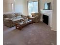 A comfortable living room featuring carpet, a sofa, and a fireplace for relaxation and warmth at 3360 Cactus Shadow St # 203, Las Vegas, NV 89129
