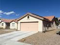 Spacious two-car garage featuring a long driveway and desert landscaping for easy maintenance and curb appeal at 4618 Zia Ridge St, North Las Vegas, NV 89031