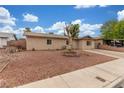 Charming single-story home featuring desert landscaping and a vintage wagon wheel in the front yard at 5109 Gains Mill St, Las Vegas, NV 89122
