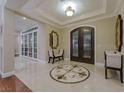 Elegant foyer with tile flooring, a decorative in-lay, an ornate double door entry, and a seating area at 52 Innisbrook Ave, Las Vegas, NV 89113