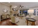 Cozy living room with a fireplace, hardwood floors, comfortable seating, and large windows looking out to the pool at 52 Innisbrook Ave, Las Vegas, NV 89113
