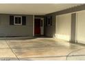 Home exterior featuring a covered parking area with a red front door and dark shutters at 5804 Balzar Ave, Las Vegas, NV 89108