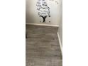 View of a home's hallway with grey wood-look floors and decorative wall art at 5804 Balzar Ave, Las Vegas, NV 89108